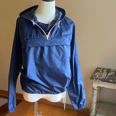 Navy blue outer shell with attached drawstring hood, 1/4 zip, front hidden zip pocket. Drawstring hem, back shoulder vents.  Made in Canada.  Freshly hand washed and ready to wear. Please use the measurements for fit.   Taken flat Pit to pit 21"  Sleeve 24" Length from collar seam 25" Because sizing is not universal among makers or across decades, size numbers are just a starting point. To ensure proper fit, you must measure and compare to a garment that fits you well. There really is no other way. Please be aware, if you need an exact color match, that colors vary from monitor to monitor. I do my best to write accurate descriptions, and I photograph in natural daylight. If you need additional information please ask before purchase to avoid disappointment. Navy Windbreaker With Double-lined Hood For Outdoor, Navy Windbreaker For Fall Outdoor, Navy Windbreaker For Outdoor Fall Use, Navy Windbreaker For Outdoor Fall Occasions, Blue Hooded Windbreaker With Double-lined Hood, Navy Hooded Jacket For Outdoor Fall Activities, Navy Hooded Jacket For Fall Outdoor Activities, Navy Sporty Windbreaker With Drawstring Hood, Navy Windbreaker For Fall Outdoor Activities