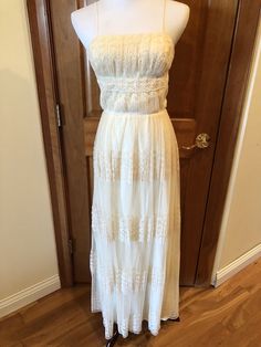 a white dress is displayed on a mannequin stand in front of a door