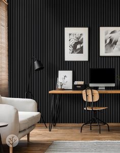 a black and white living room with wood flooring, two framed pictures on the wall