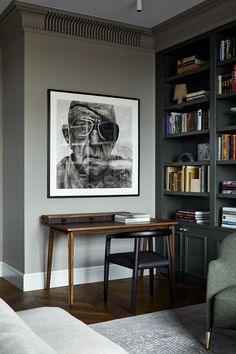 a living room filled with furniture and bookshelves next to a painting on the wall