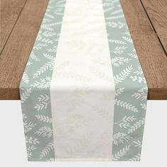 a table with a white and blue runner on it's side, next to a wooden bench