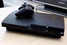 a sony playstation is sitting on a table next to a laptop