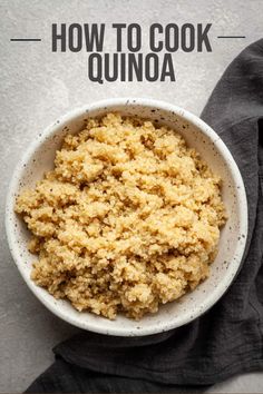 a white bowl filled with quinoa on top of a gray cloth next to a black napkin