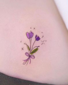 a woman's stomach with purple flowers and stars on the back of her body