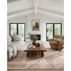 a living room with couches, chairs and a coffee table in front of two windows