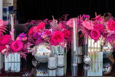 three vases filled with pink flowers sitting on top of a table next to each other