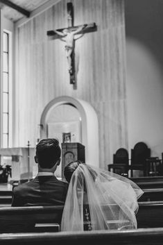 a bride and groom sitting in the pews of a church