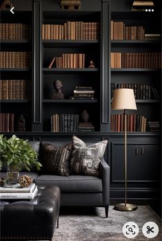 a living room with black bookshelves and leather couches, coffee table and lamp