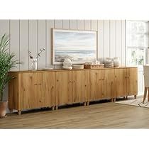 a living room scene with focus on the large wooden sideboard and potted plant