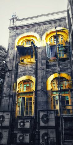 an old building with yellow windows and balconies