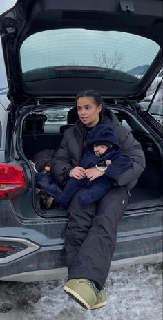 a woman sitting in the back of a car with her child