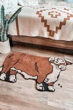 a brown and white dog rug on the floor next to a bed in a bedroom