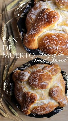 two breads sitting on top of a black and white plate covered in powdered sugar