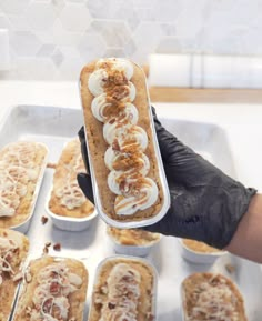 a person in black gloves is holding a tray with desserts