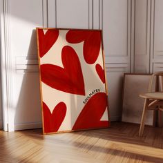 a wooden chair sitting next to a red and white painting on the wall in an empty room