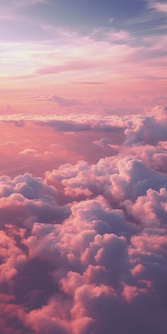 the sky is filled with clouds and pink hues as seen from an airplane window