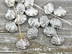 some silver colored leaves on a wooden surface