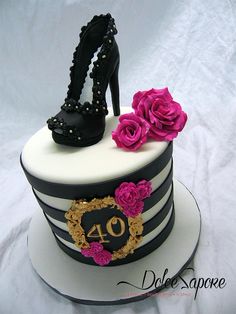 a cake decorated with black and white stripes, pink flowers and high heeled shoes