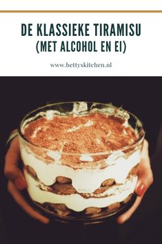 a person holding a glass bowl filled with food and the words de klasssieke tramisu met alcohol en el