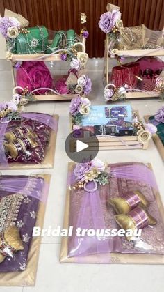 several bags and purses are on the table with purple flowers in them, along with other items