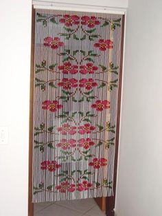 a room with a white wall and red flowers on the blinds