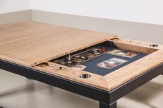 a wooden table with an open drawer on the top that has cards and games in it