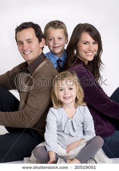 a family sitting on the floor with their arms around each other