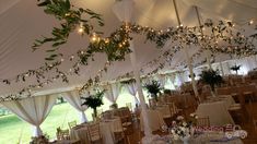 the inside of a large tent with tables and chairs set up for a wedding reception