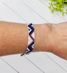 a woman's arm wearing a bracelet with blue and white designs on the wrist