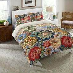 a bed covered in a colorful floral comforter