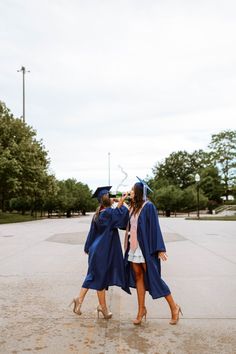 two girls in graduation gowns walk together