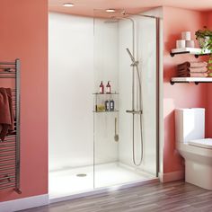 a bathroom with pink walls and white fixtures, including a walk in shower next to a toilet