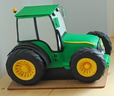 a green toy tractor sitting on top of a wooden table