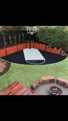 an outdoor basketball court surrounded by brick walls and grass with fire pit in the middle