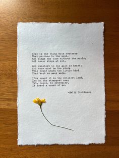 a piece of paper that has a yellow flower on it and a poem written in black ink