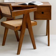 a wooden desk with a book on top of it and a chair next to it