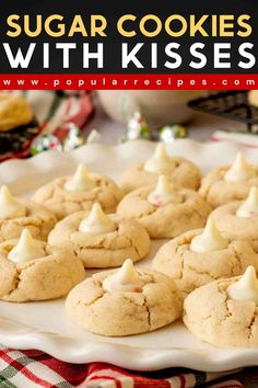 sugar cookies with kisses on a white platter next to other cookies and marshmallows