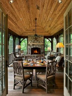 an outdoor dining area with wood flooring and wooden ceiling, along with glass doors leading to the outside deck