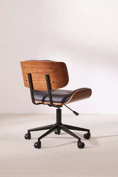 an office chair with black leather seat and wheels on the back, in front of a white wall