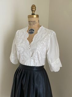 "This is a gorgeous women's white short sleeve, fitted cotton eyelet blouse. This will fit a size medium to large; the bust measures roughly 38\". This has a button-down bodice and charming sleeves! +Not part of the wholesale deal+ Please use my measurements to guide you, all sales are final. The measurements were taken with the shirt laying flat. ✂ - - - Measurements Length- Approx. 22-1/2\" Laying flat measuring from the shoulder down to the hem Bust- will fit approx. 38\" measuring at the arm Vintage White Blouse, Fitted White Victorian Blouse, White Fitted Victorian Blouse, Victorian White Blouse With Lace Collar, White Cottagecore Blouse With Lace Collar, Vintage Button-up Blouse With Lace Collar, Vintage Blouse, Cottagecore Blouse, Victorian Blouse