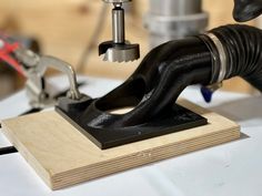 a machine that is working on some kind of woodworking project with tools in the background