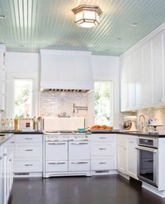 a kitchen with white cabinets and black counter tops is seen in this image from the front view