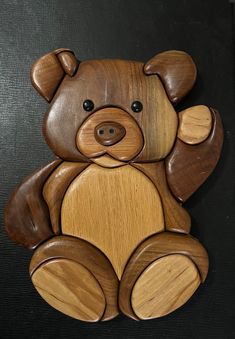 a wooden teddy bear sitting on top of a table