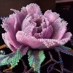 a beaded rose is sitting on a table