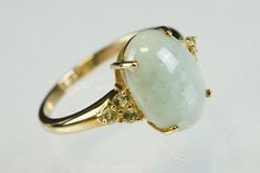 Beautiful vintage ring set with an oval pale green jade cabochon with three small round peridot stones prong set to each shoulder. The jade has some delicate marbling and the peridots set this off elegantly. Cabochon is 1 x 1.4cm. Ring shank has a slight flair to the head and is marked 9ct gold. The ring has been carefully cleaned to be loved all over again.  Ring size: UK P; US 7 1/2. Total width of head of ring 1.4 x 1.4cm (3.7gm weight) Shipping and packaging: Your ring will be beautifully boxed with a ribbon (vintage box in photos is for display purposes only and actual packaging is shown separately). Sent within 1-3 working days.  If you're in the UK your Joyful delivery will be sent by Royal Mail 1st class tracked. Etsy will let you know when it's on its way. Overseas deliveries are Chain Threader Earrings, Beautiful Rings Vintage, Marcasite Ring, Peridot Stone, Jade Ring, Etsy Gold Ring, Solid Gold Rings, Sterling Silver Flowers, Blue Quartz