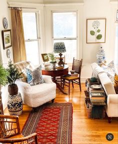 a living room filled with lots of furniture and decor on top of hard wood floors