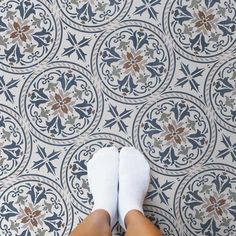 a person standing in front of a tile floor with their feet up on the ground