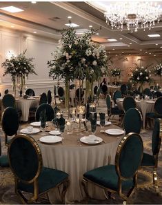 a banquet room set up with tables and chairs for formal function, including centerpieces