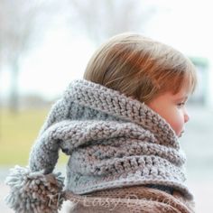 a young child wearing a knitted scarf