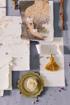 the wedding stationery is laid out on top of each other, including an ornate brooch